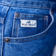 Close-up of blue denim jeans with a 'Wop-Wops' label on the pocket.