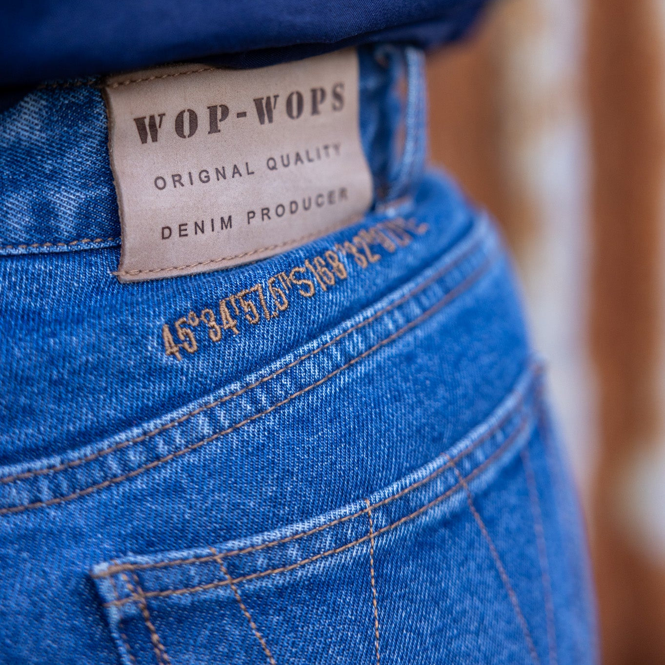 Close-up of blue denim jeans with a visible brand label.