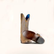 Tan cowboy boot with decorative pattern on a white background