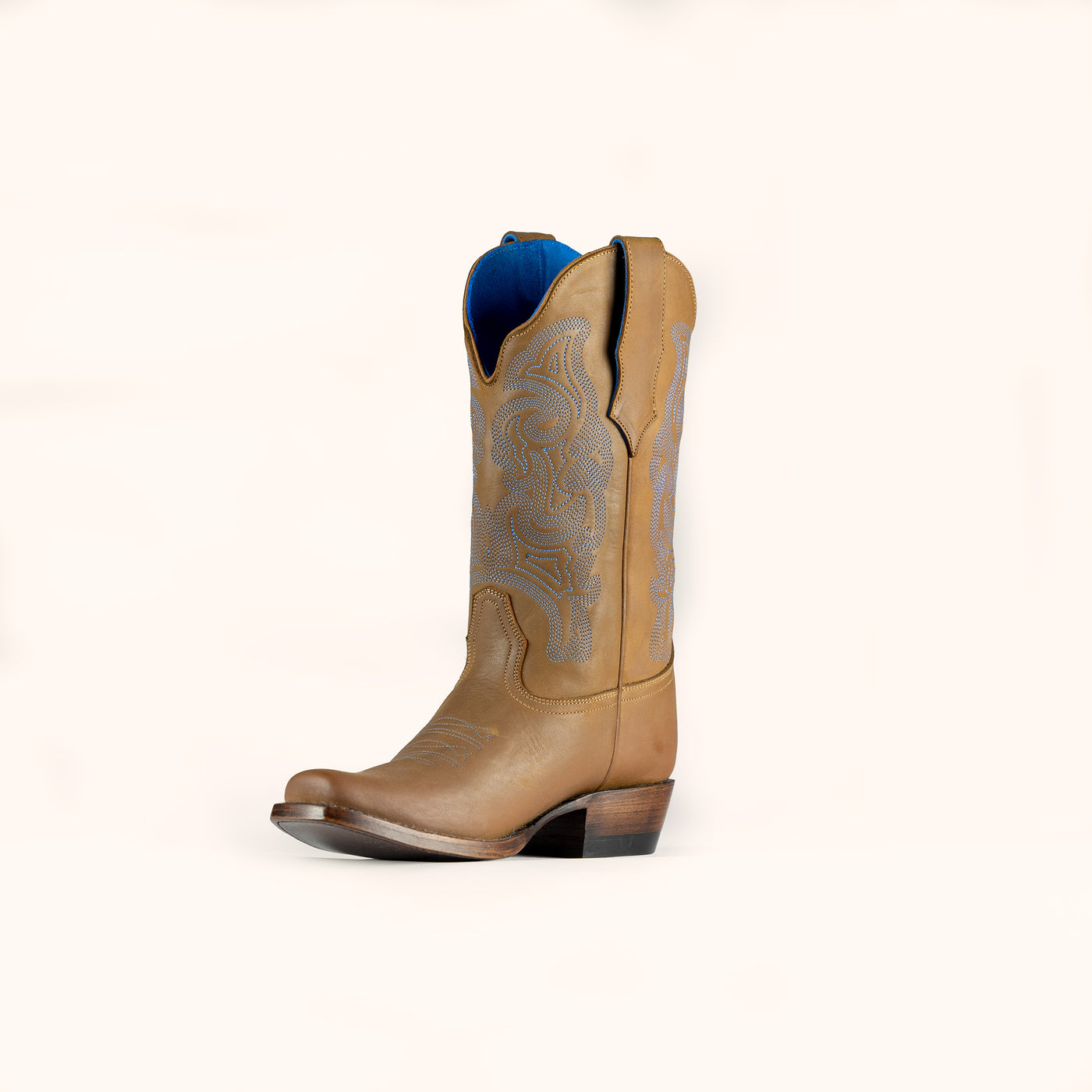Tan cowboy boot with decorative pattern on a white background