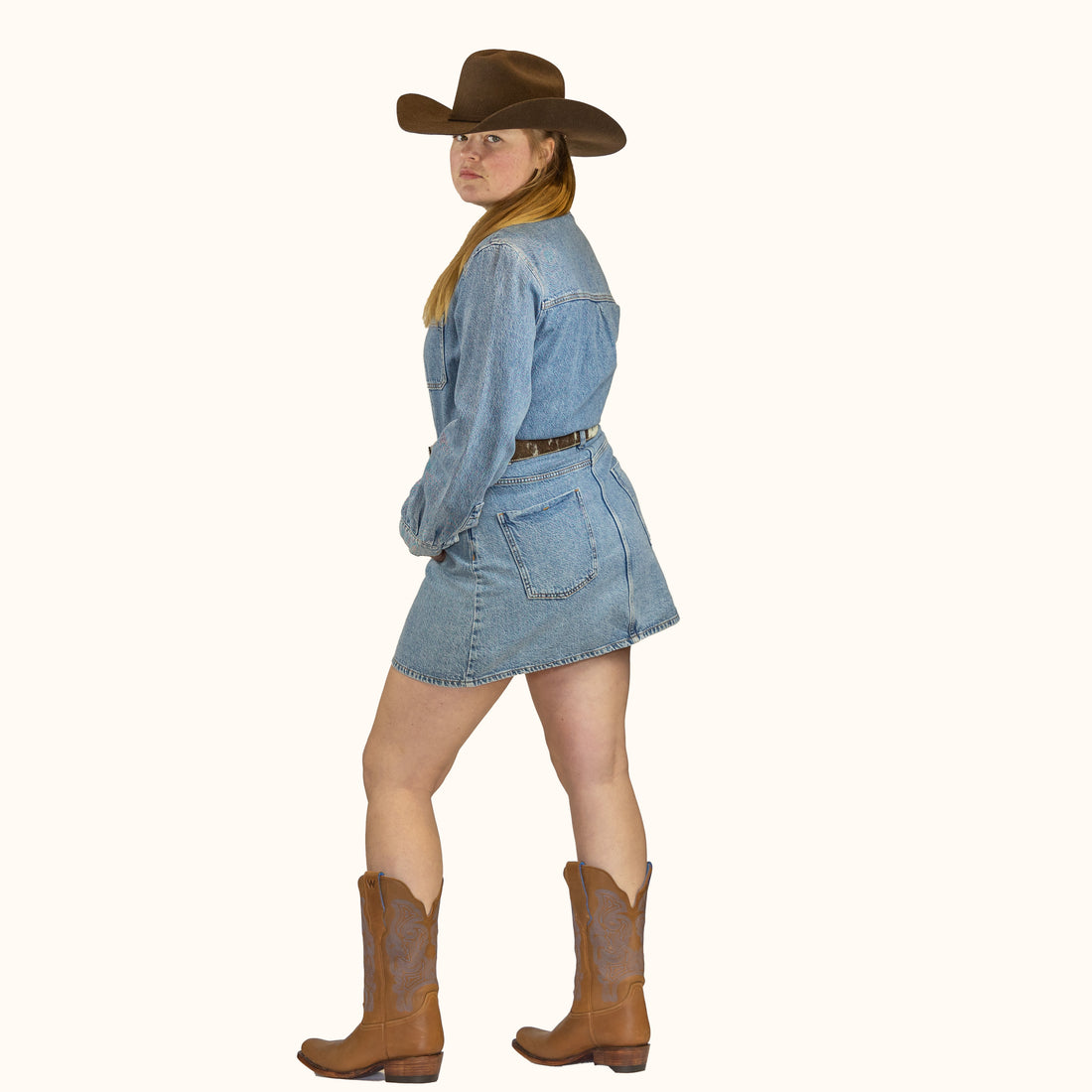 Tan cowboy boot with decorative pattern on a white background