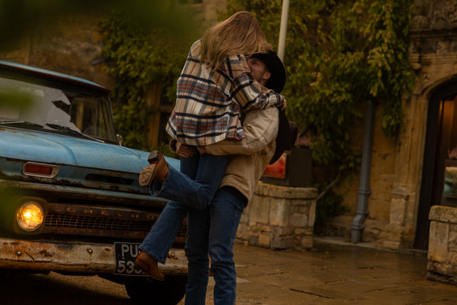 Couple outside hotel in broadway with a vintage Chevrolet parked behind